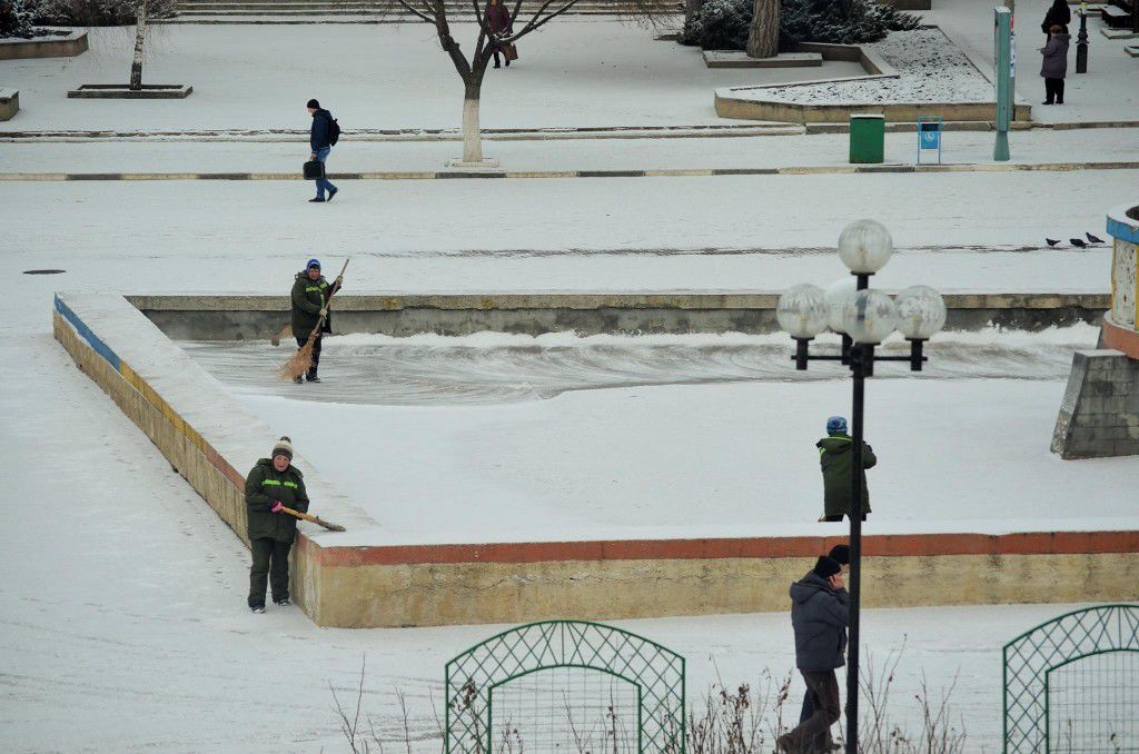 В Бельцах во время снегопада подметают фонтан