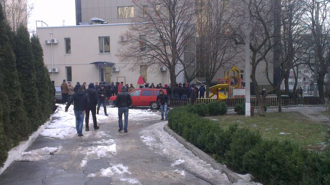 Десятки молодых людей спортивного телосложения собираются у офиса Плахотнюка