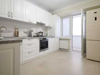 Bucătărie neoclasică albă cu fațade frezate.