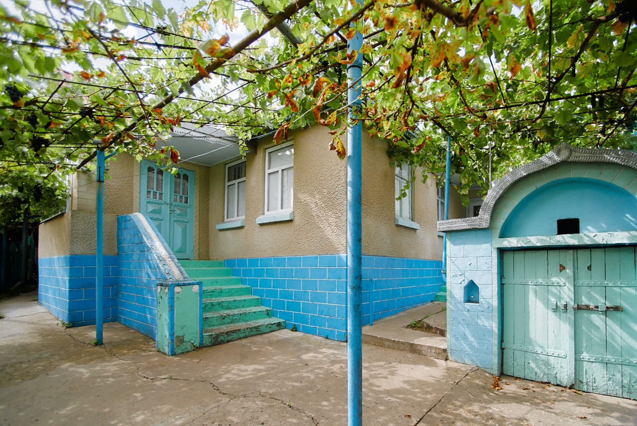 Casa din cotileț pe un teren de 8 ari, garaj, construcții accesorii