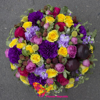 O cutie plină cu flori într-o gamă de galben-roz-violet 