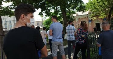 Люди стоят в очереди у наркодиспансера, чтобы оформить документы на водительские права. Фото: zdg.md