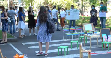 Участники митинга пришли протестовать с плакатами, игрушками, а также предметами детской мебели.