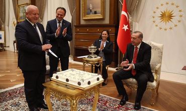 Депутат парламента Республики Молдова Нае Симион Плешка собирается разрезать подаренный торт.