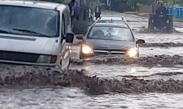 На видео видно, что недавние дожди сильно затопили улицу, по которой автомобили едва могут ехать.