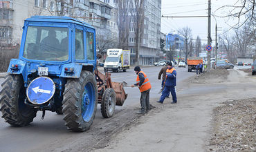 Муниципальные службы собирают песок с обочин дорог.