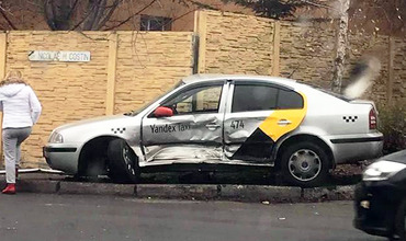 Автомобиль такси отбросило в ограждение частного жилого дома.