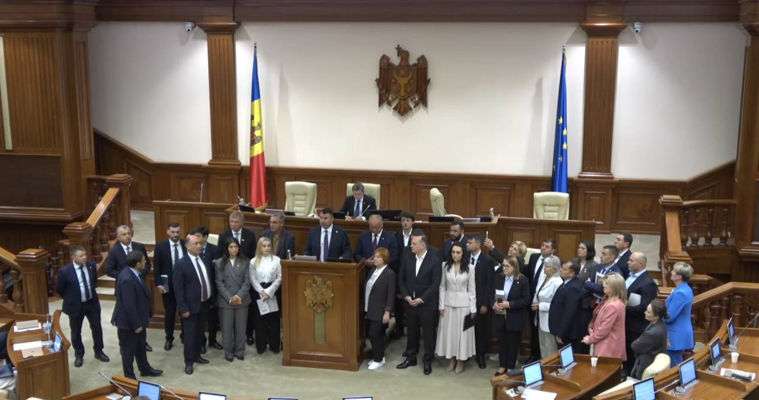 Оппозиция заблокировала парламентскую трибуну и покинула заседание.