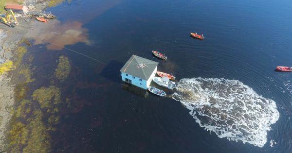 Семейная пара из Канады перевезла 100-летний дом по воде на другой берег.
