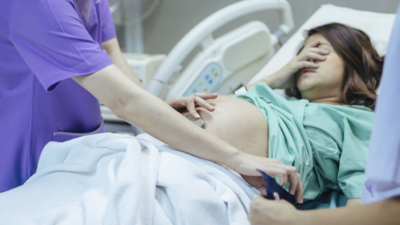 Femeie gravidă, obligată să nască legată cu cătușele de pat