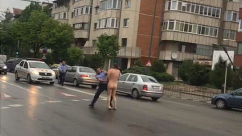 Bărbat complet dezbrăcat, încătușat de polițiști pe o stradă din România