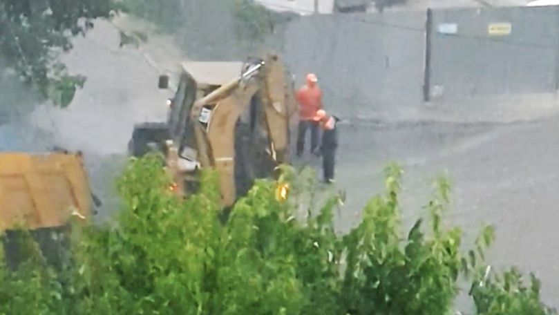 Muncitori, filmați cum toarnă asfalt pe ploaie în Chișinău