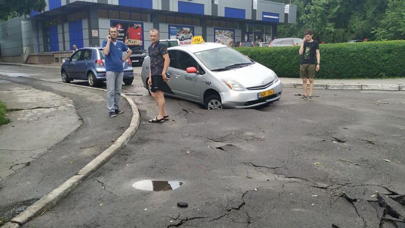 Un taximetrist a ajuns cu roata în asfalt după ce drumul s-a surpat