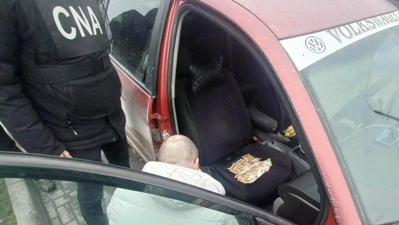 Un polițist, reținut în flagrant: Pentru ce a primit 1.000 de euro