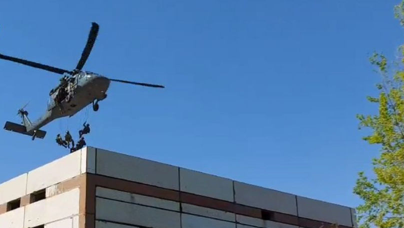 Momentul în care mascații sar din elicopter pe acoperișul unei clădiri