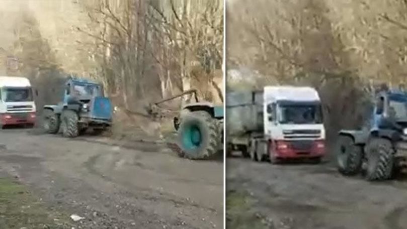 Două tractoare, filmate cum tractează un camion la Camenca