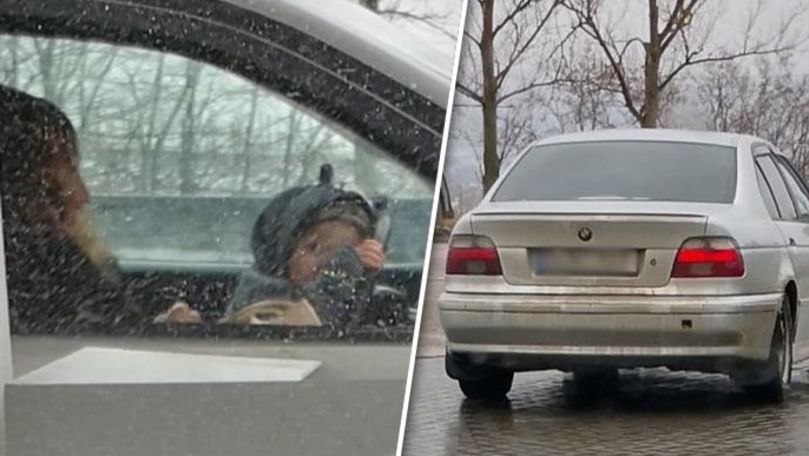 Un șofer, surprins cum conduce BMW-ul cu un copil în brațe