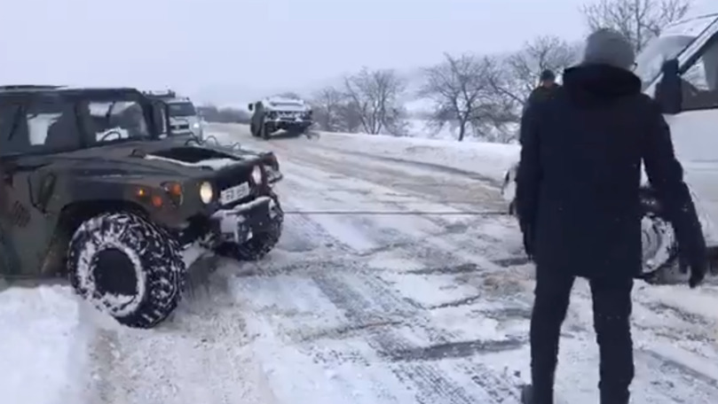 Gaburici și Sturza scot mașinile blocate în zăpadă cu un Humvee