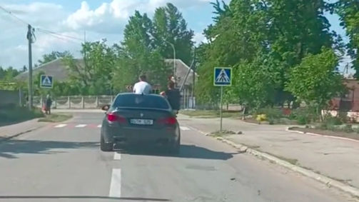 Tineri, filmați cum circulă pe trapa și în afara geamului unei mașini