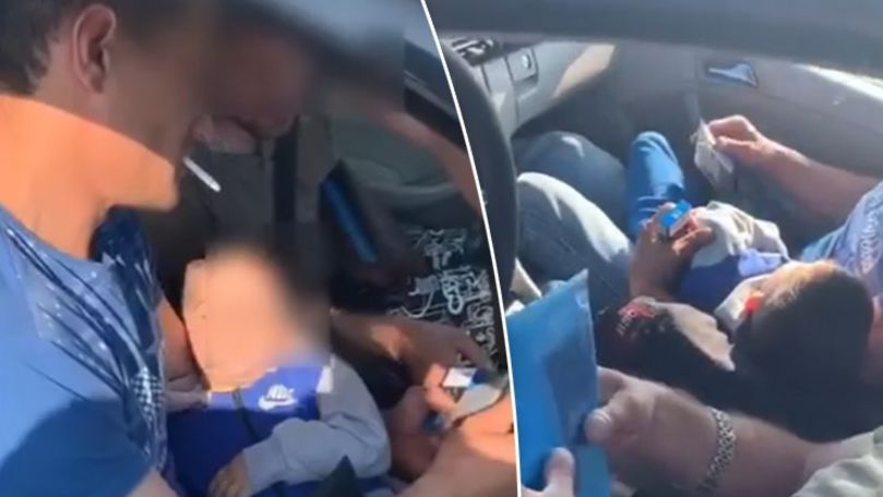 Bărbat, filmat cum fumează în mașină cu un copil în brațe