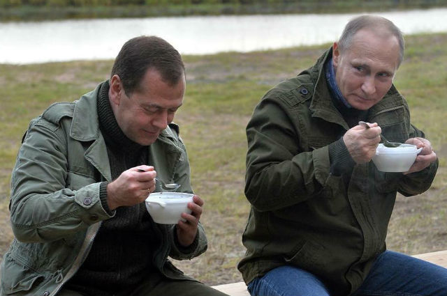 Одетые в куртки цвета хаки и джинсы, Путин и Медведев увидели, как рыбаки неводом ловят рыбу.