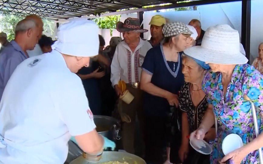 В столице пожилые люди выстраиваются в очередь за обедом в социальной столовой.