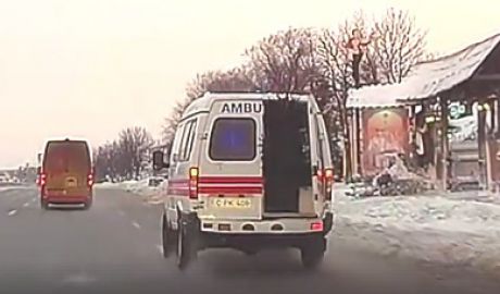 O ambulanță care transportă brazi, filmată cum trece pe roșu