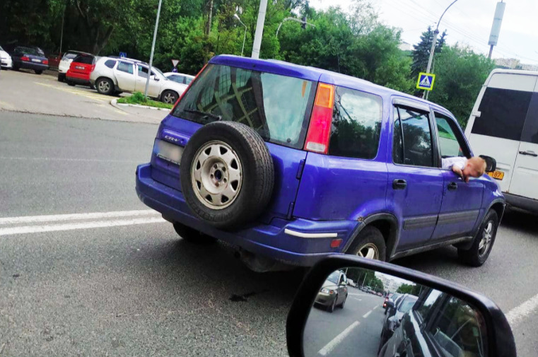 Водитель авто ехал с высунувшимся в окно маленьким ребенком.