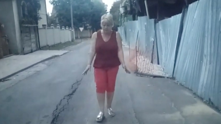 На записи показан просевший асфальт дороги, впритык к которой строители поднимают здание.