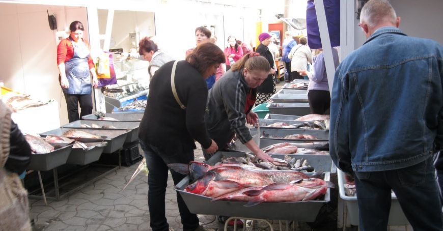 На Центральном рынке некоторые продавцы продают продукты питания на солнце.
