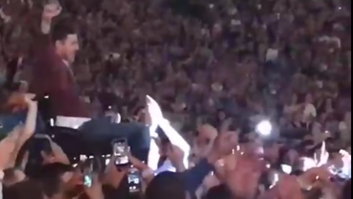 Un fan Coldplay în scaun cu rotile, purtat pe brațe de mulțime până la scenă. Foto: Captură video