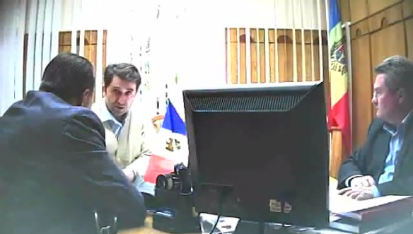 Котец разговаривает с просителями, при этом требуя "долю" за свою подпись под документами.