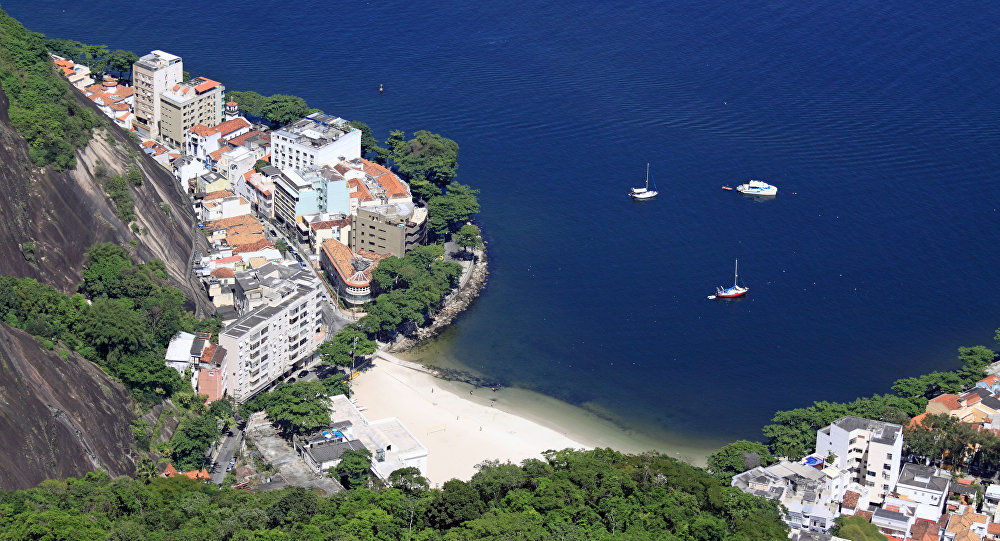 Bancnote risipite pe o plajă din Rio de Janeiro. Foto: Wikipedia/ Halley Pacheco de Oliveira