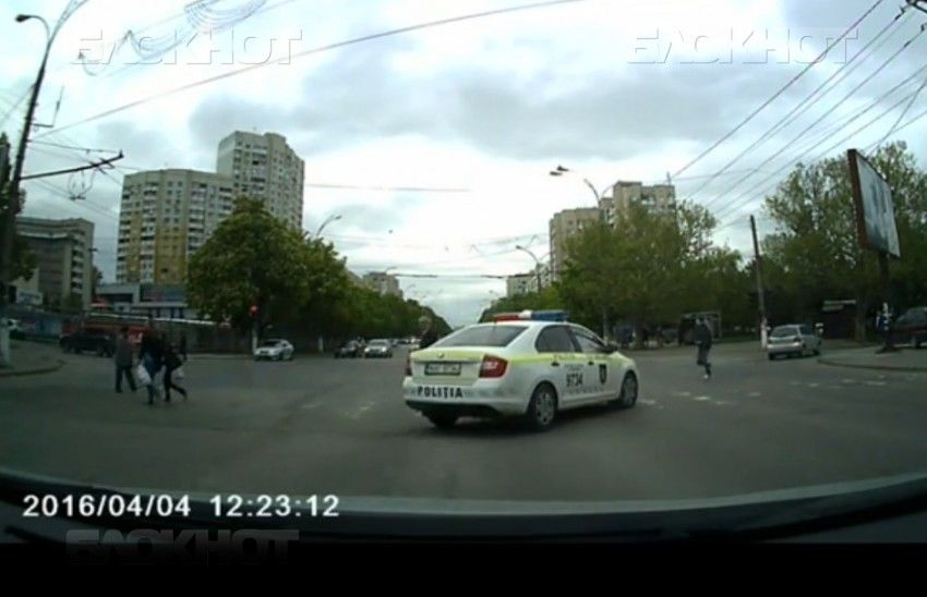 Автомобиль, практически не сбавляя скорости, лавирует между людьми, переходящими дорогу.