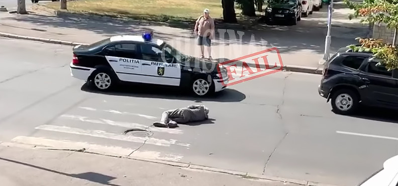 В Кишиневе машина полиции объехала мужчину, лежащего поперек дороги.