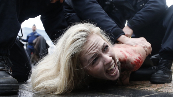 Femen, au aprins de asemenea fumigene roşii, o parodie a fumului alb care trebuie să iasă de pe coşul capelei Sixtine pentru a anunţa alegerea unui nou papă.