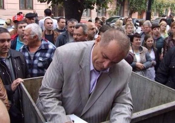 Активисты принесли к зданию Черновицкой ОГА мусорный бак, в который  посадили главврача  госпиталя ветеранов войны Манолия Мигайчука.