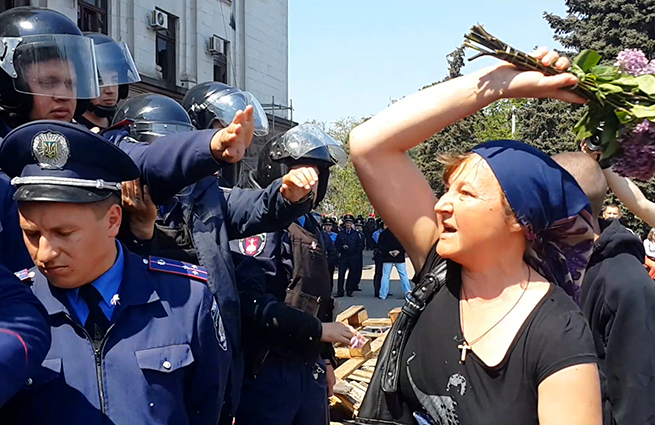 Видя отчаяние женщины, толпа начала скандировать в сторону стражей порядка "позор!".