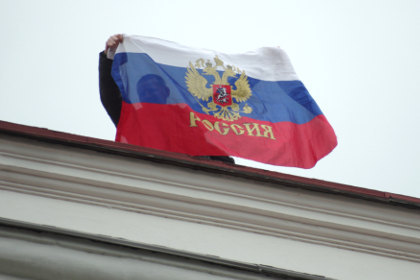 Местный житель с российским флагом на крыше горсовета в Севастополе. Фото: Василий Батанов / РИА Новости