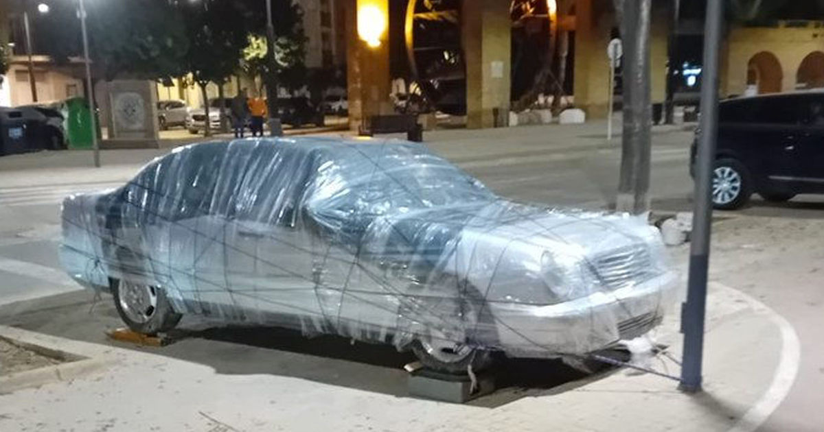 Spaniolii leagă mașinile de stâlpi și le învelesc cu peliculă după o nouă avertizare de ploi.