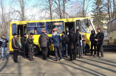 Мужчины стоят возле автобусов, которые расположены недалеко от Дворца спорта. Фото: mediaport.ua