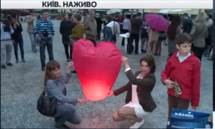 Собравшиеся на Почтовой площади в Киеве горожане запускают воздушные фонари.