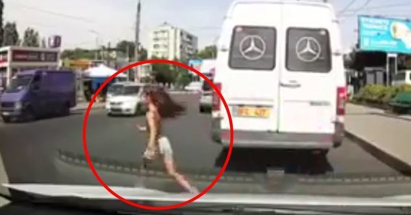 Девочка бегала между машинами, пытаясь поймать собаку.