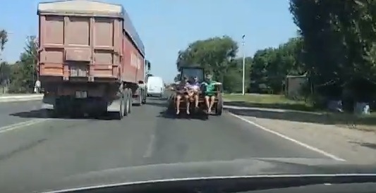 В Комрате тракторист прокатил детей на краю прицепа.