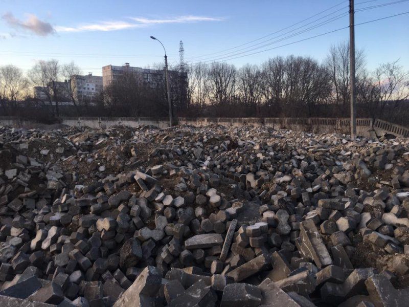 Под открытым небом свалены горы плитки.