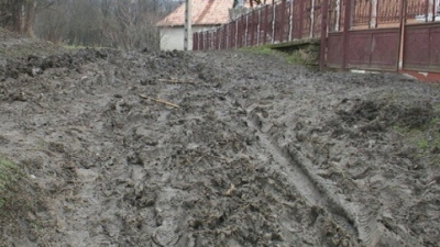 Tractorul este singurul mijloc de transport care face faţă noroiului de pe drumurile din localitate.