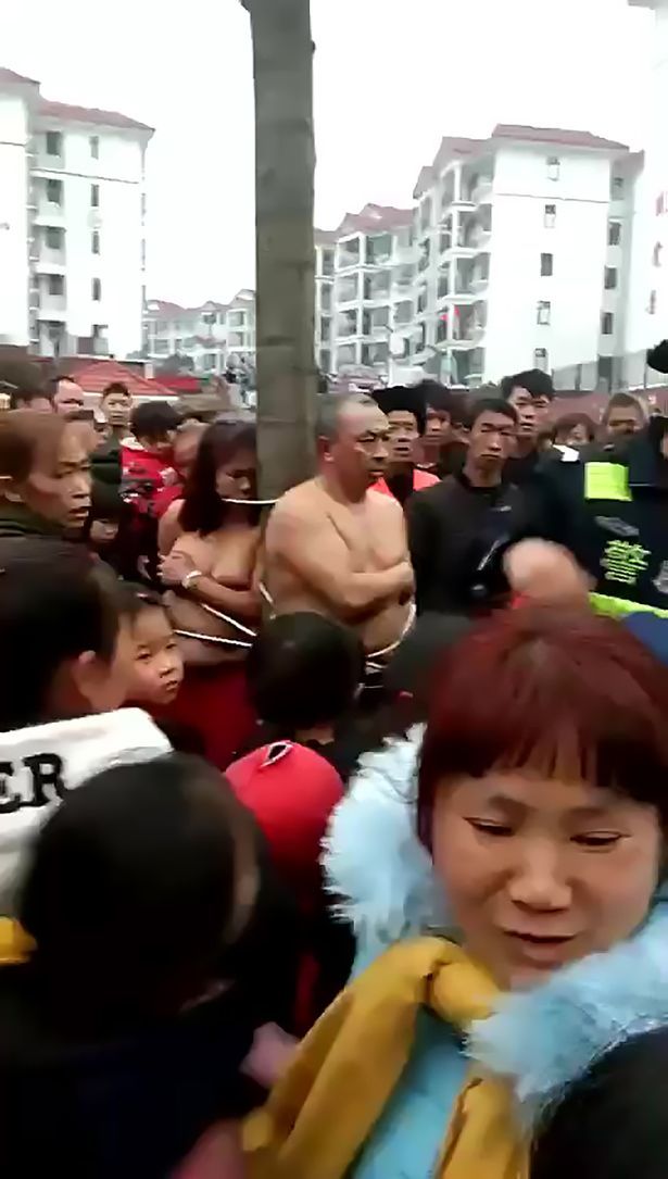 Китаянка, уличившая мужа в измене, выгнала его с любовницей на улицу и привязала голыми на площади к дереву посреди толпы.