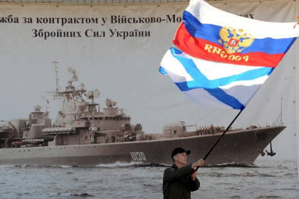 Житель Севастополя с флагами России и ВМФ. РФ Фото: Виктор Драчев / AFP
