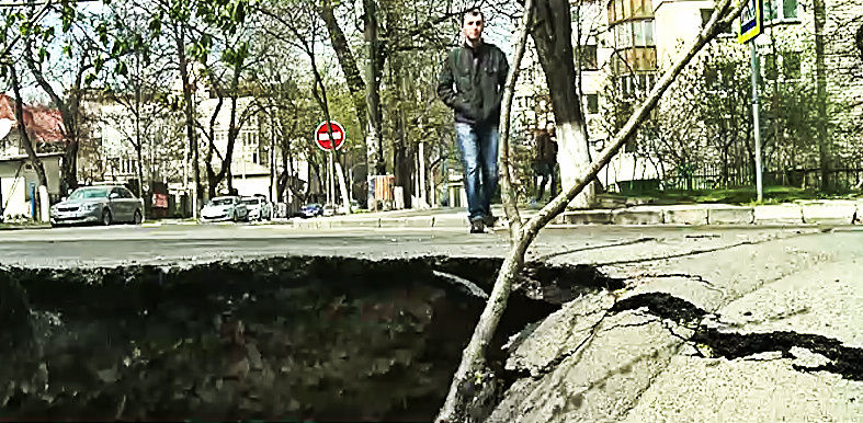 Асфальт прогнулся и треснул из-за того, что вымыло почву после ремонта водопроводных сетей.