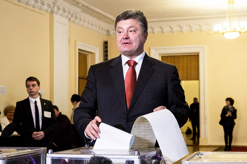 Президент Украины Петр Порошенко (на первом плане) во время голосования на досрочных выборах в Верховную раду Украины на одном из избирательных участков.